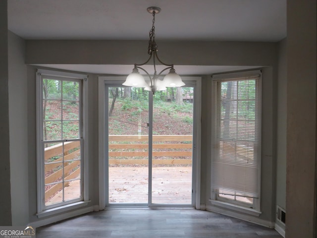 doorway with wood-type flooring and a chandelier