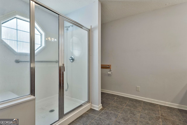 bathroom with tile floors, a textured ceiling, and a shower with shower door