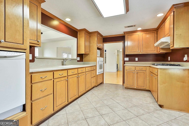 kitchen featuring white oven, stainless steel gas cooktop, sink, refrigerator, and light tile floors