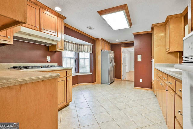 kitchen with a textured ceiling, stainless steel refrigerator with ice dispenser, gas cooktop, and light tile floors