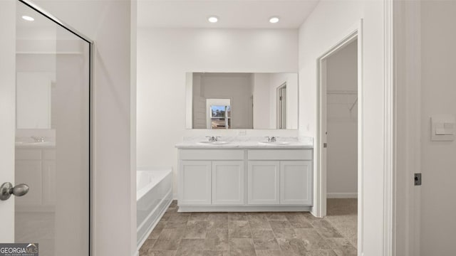 bathroom with vanity and a tub to relax in