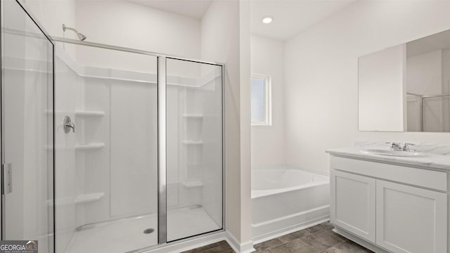 bathroom featuring plus walk in shower and vanity