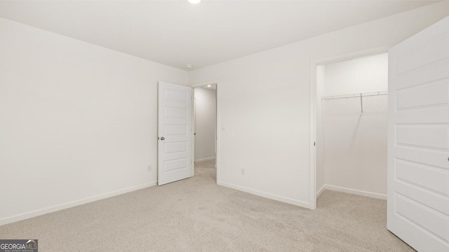 unfurnished bedroom with light carpet and a closet