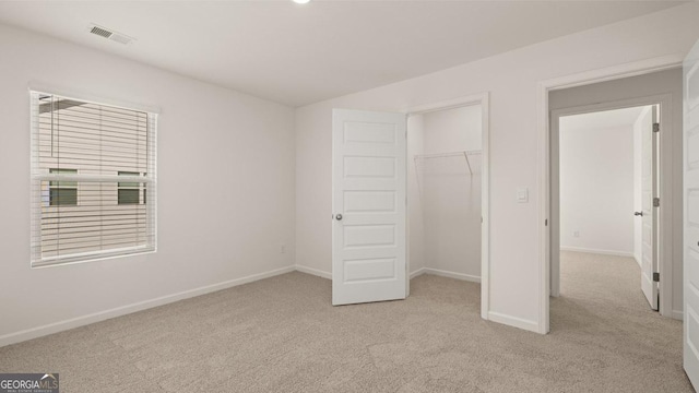 unfurnished bedroom featuring light colored carpet and a closet