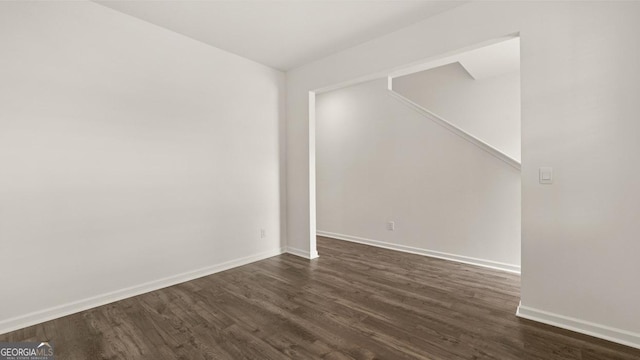 unfurnished room with dark hardwood / wood-style flooring