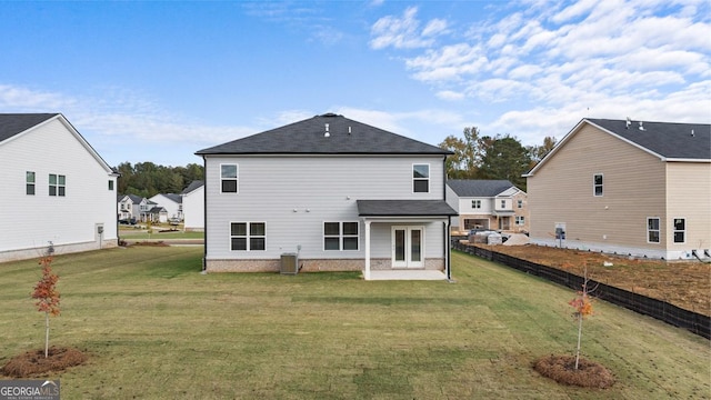 rear view of property featuring a patio area, central AC, a yard, and french doors