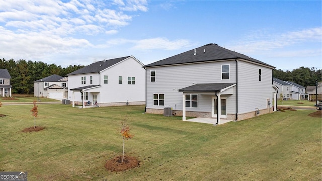 back of house with a lawn, central air condition unit, and a patio