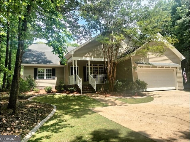 view of front of home with a garage, a front lawn, and covered porch