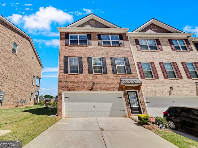 townhome / multi-family property with a garage and a front yard