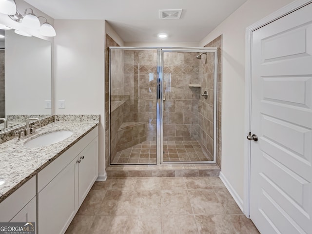 bathroom with tile floors, a shower with door, and vanity