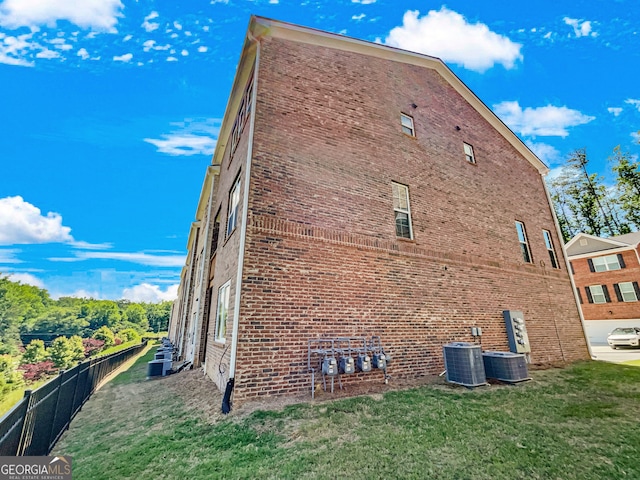 view of home's exterior with a yard and central air condition unit