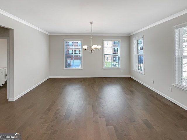 spare room with a chandelier, crown molding, and dark hardwood / wood-style flooring