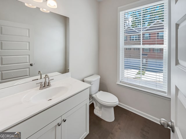 bathroom featuring wood-type flooring, vanity, and toilet