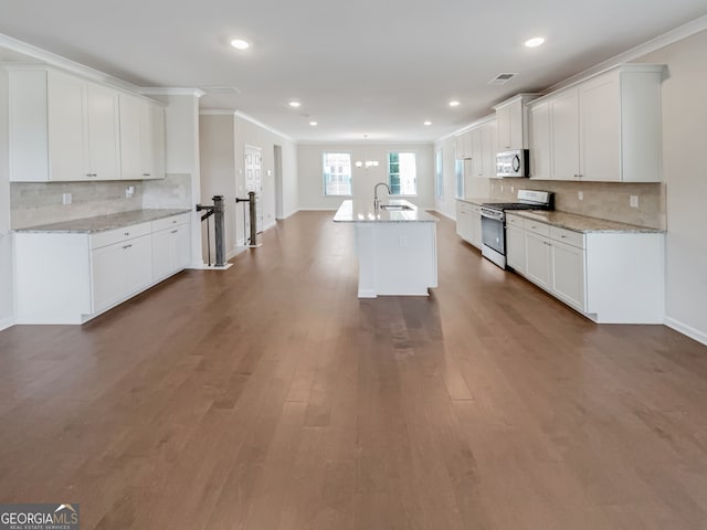 kitchen with backsplash, ornamental molding, dark wood-type flooring, white cabinets, and range with gas cooktop