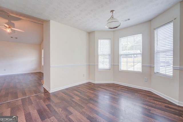 spare room with a textured ceiling, dark hardwood / wood-style floors, and ceiling fan