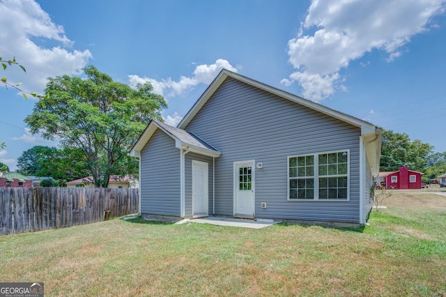 rear view of property with a lawn