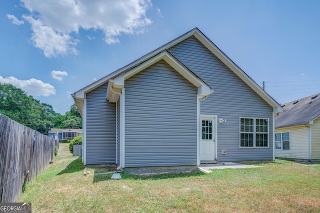 rear view of house featuring a yard