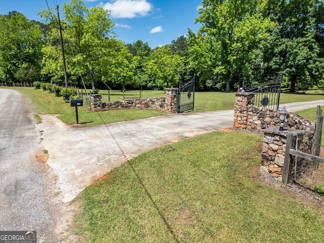 view of gate with a lawn