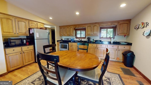 kitchen with light hardwood / wood-style floors, lofted ceiling, stainless steel range oven, sink, and refrigerator