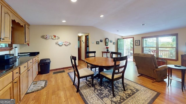 dining area with lofted ceiling and light wood-type flooring