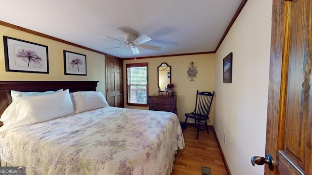 bedroom featuring hardwood / wood-style flooring, ornamental molding, and ceiling fan