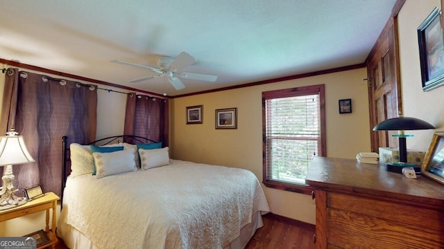 bedroom with crown molding, dark wood-type flooring, and ceiling fan