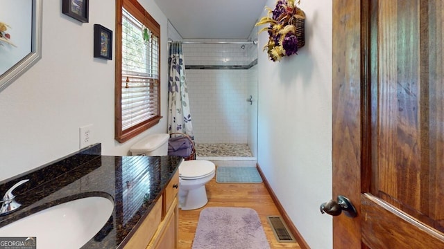 bathroom featuring curtained shower, hardwood / wood-style floors, toilet, and vanity