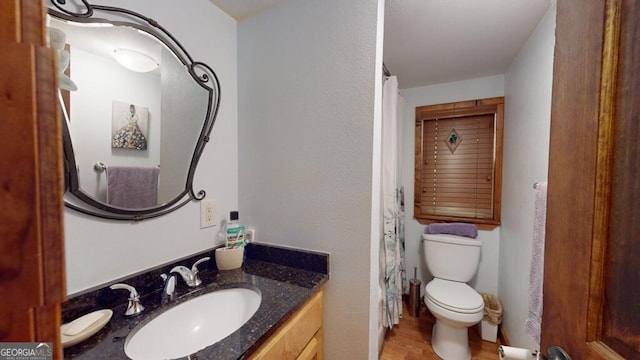 bathroom featuring wood-type flooring, vanity, and toilet