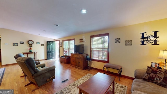 living room with vaulted ceiling and hardwood / wood-style floors