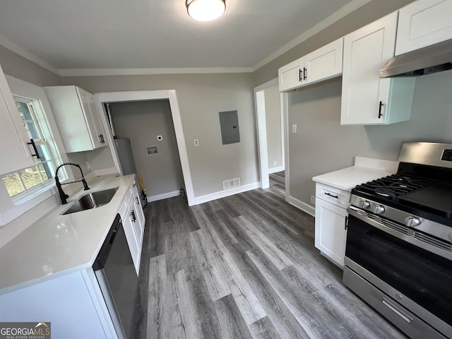 kitchen with white cabinetry, wall chimney range hood, gas stove, hardwood / wood-style floors, and sink