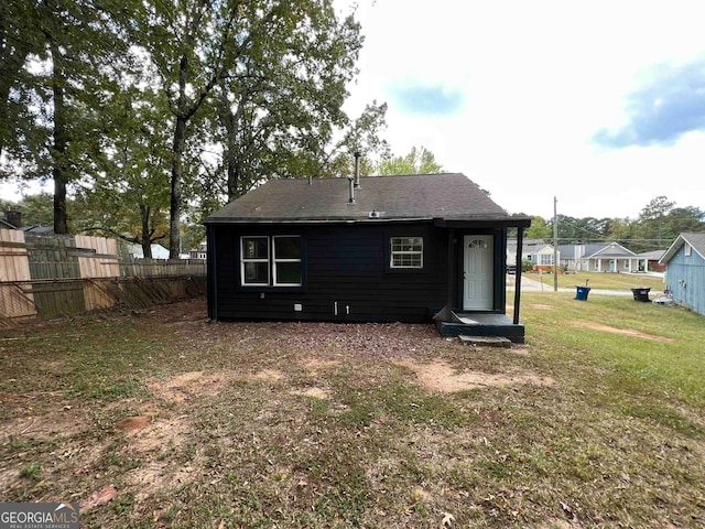 rear view of property with a lawn