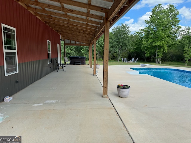 view of pool featuring a diving board, a hot tub, and a patio area