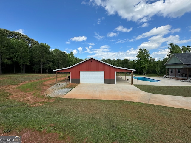 exterior space featuring a front lawn, a garage, and an outdoor structure