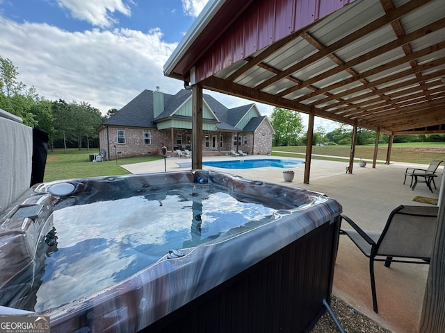 view of swimming pool with a patio and a hot tub