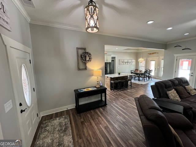 living room with a chandelier, dark hardwood / wood-style floors, and crown molding