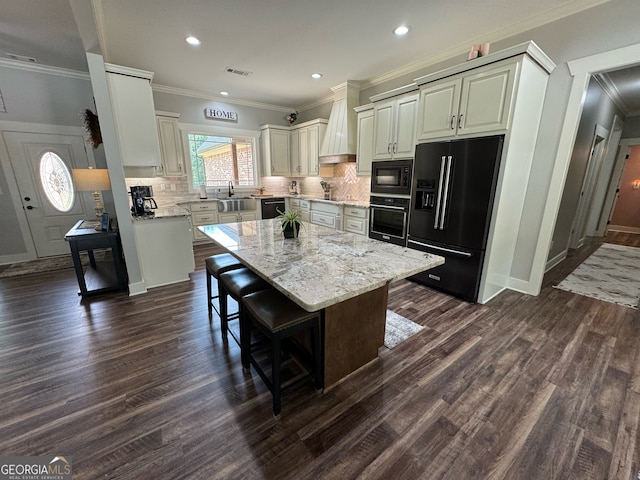 kitchen featuring a kitchen bar, black appliances, tasteful backsplash, and dark hardwood / wood-style floors