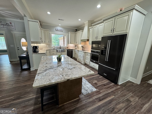 kitchen with dark hardwood / wood-style flooring, custom range hood, tasteful backsplash, crown molding, and black appliances