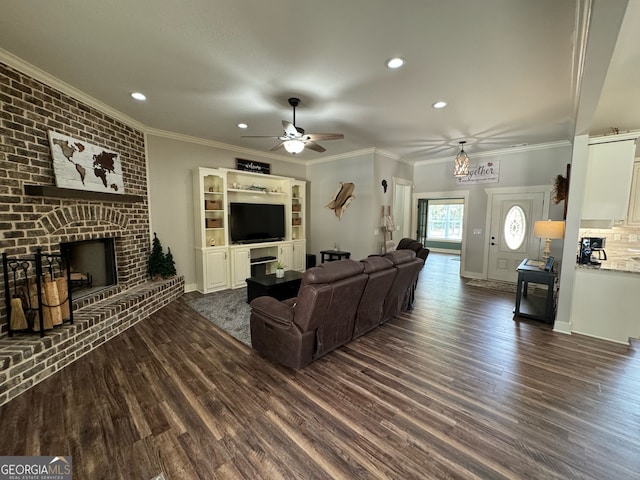 living room featuring crown molding, ceiling fan, a brick fireplace, and dark hardwood / wood-style flooring