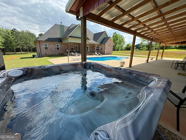 view of swimming pool with a patio area, a lawn, and a hot tub