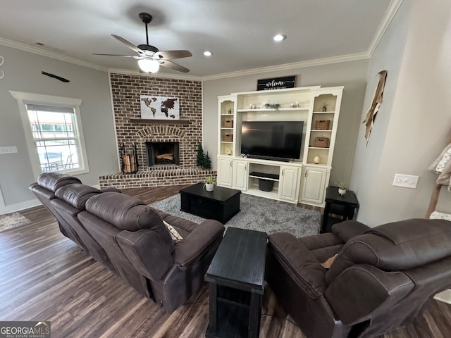 living room with ceiling fan, dark wood-type flooring, ornamental molding, and a brick fireplace