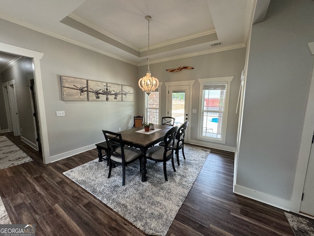 dining room featuring a tray ceiling, ornamental molding, dark hardwood / wood-style flooring, and a notable chandelier