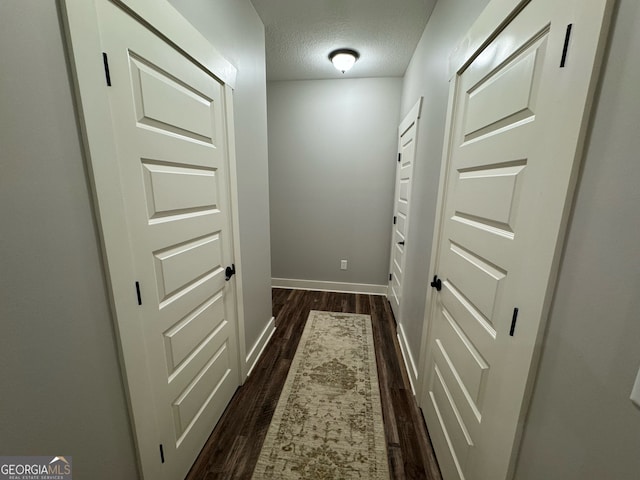 interior space with a textured ceiling and dark hardwood / wood-style flooring