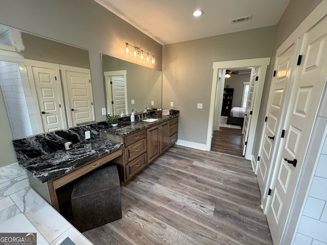 bathroom with double vanity, hardwood / wood-style flooring, and ceiling fan