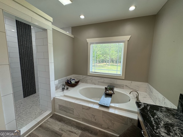 bathroom featuring wood-type flooring and plus walk in shower