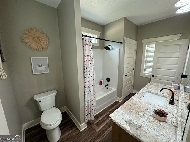 full bathroom with a wealth of natural light, shower / bath combination with curtain, vanity, and toilet