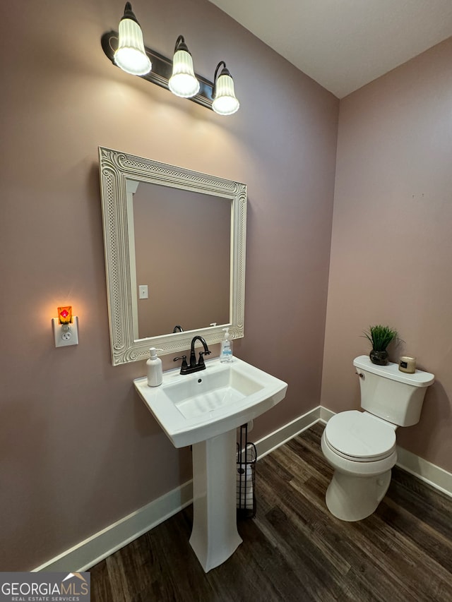 bathroom with toilet and hardwood / wood-style floors