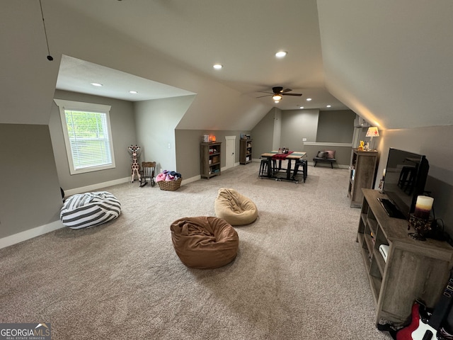 interior space featuring ceiling fan, carpet floors, and lofted ceiling