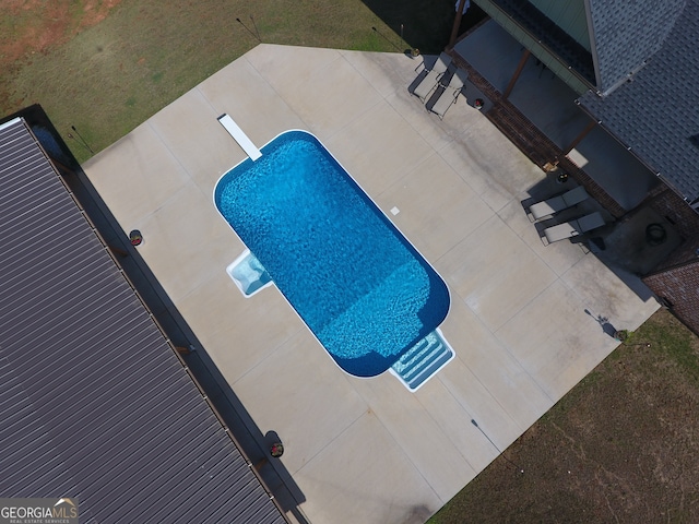 view of pool featuring a patio area and a diving board