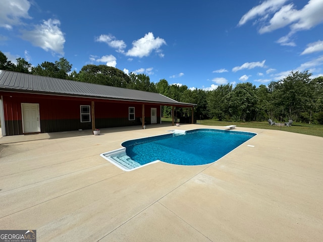 view of pool with a patio, a diving board, and a lawn