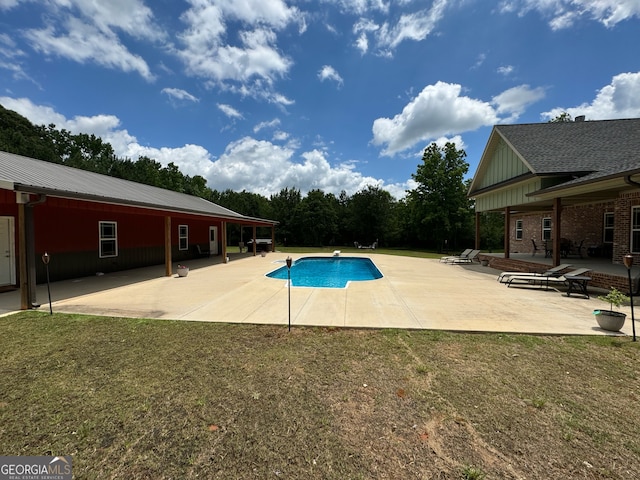 view of swimming pool with a yard and a patio area